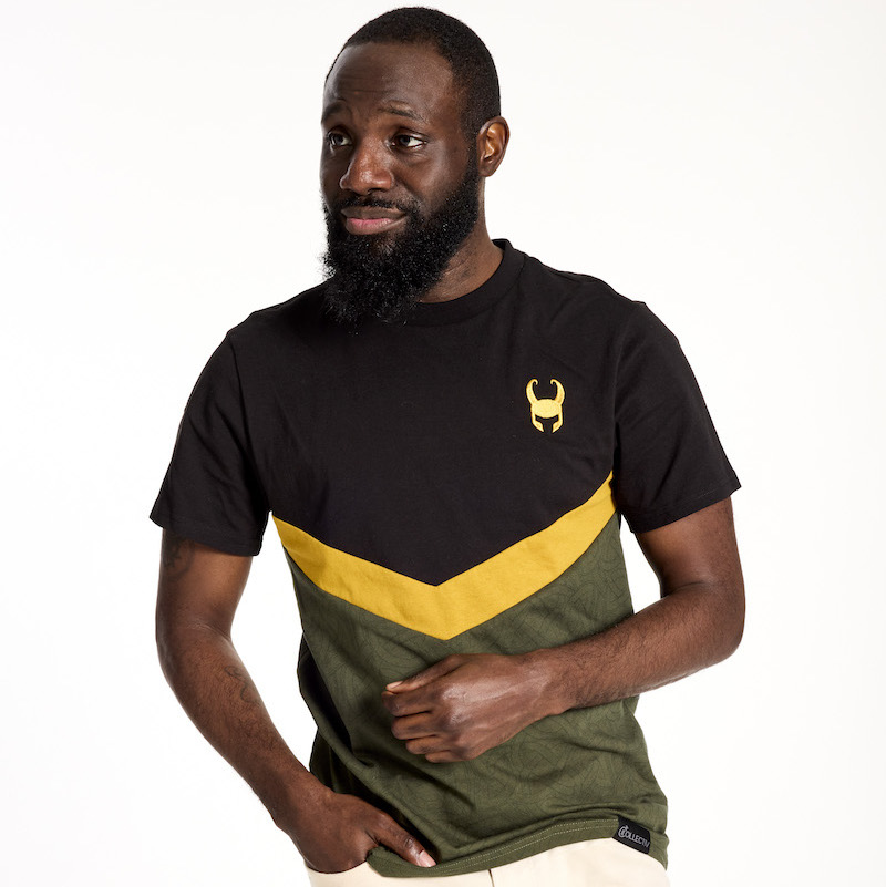 Bearded man looking off to the left and wearing the black, green, and gold Loungefly COLLECTIV Marvel Loki The ORIGINL Tee, with one hand in his pocket